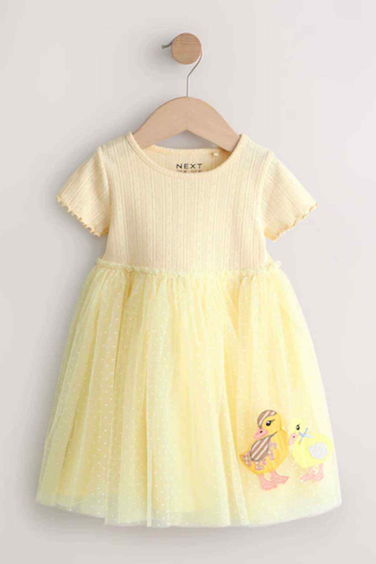 Pale yellow girls' short-sleeve dress on hanger with scalloped sleeves