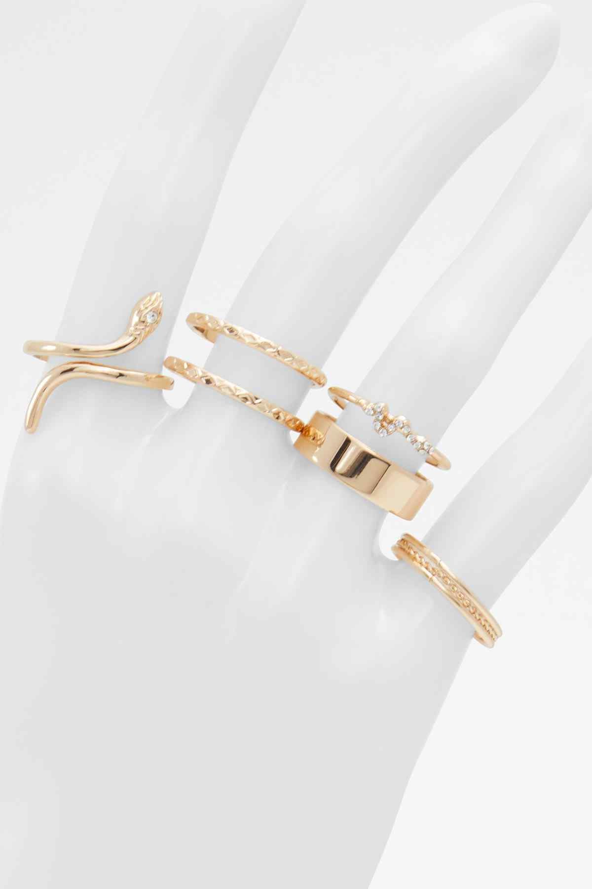 Gold-tone ring set with clear stones, layered bands on hand