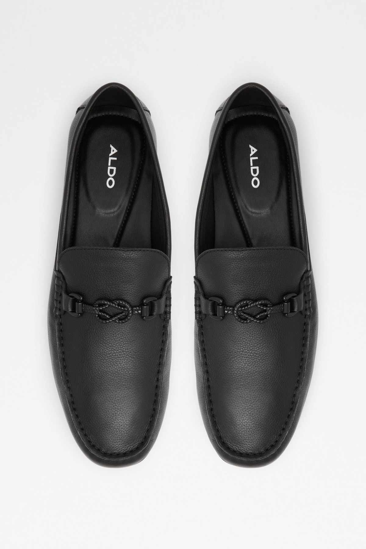 Pair of black leather loafers, front view with metal buckle strap and embossed insole logo