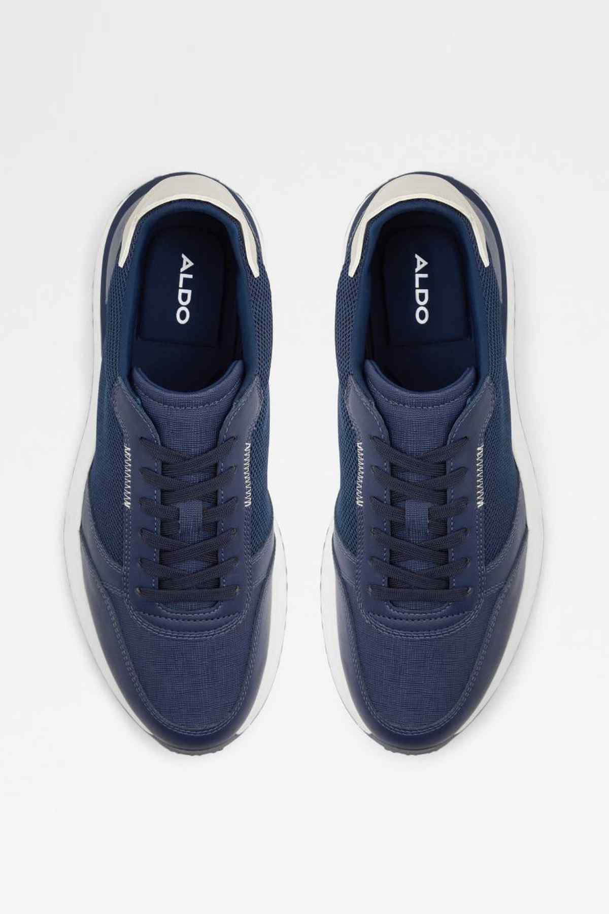 Navy sneaker pair top view with ALDO logo on tongue and white soles.