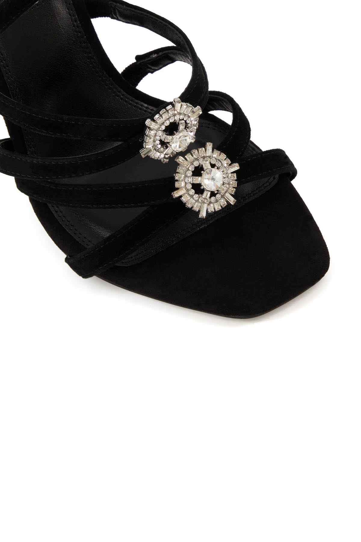 Black suede-style heeled sandals with crisscross straps and three rhinestone floral buckles
