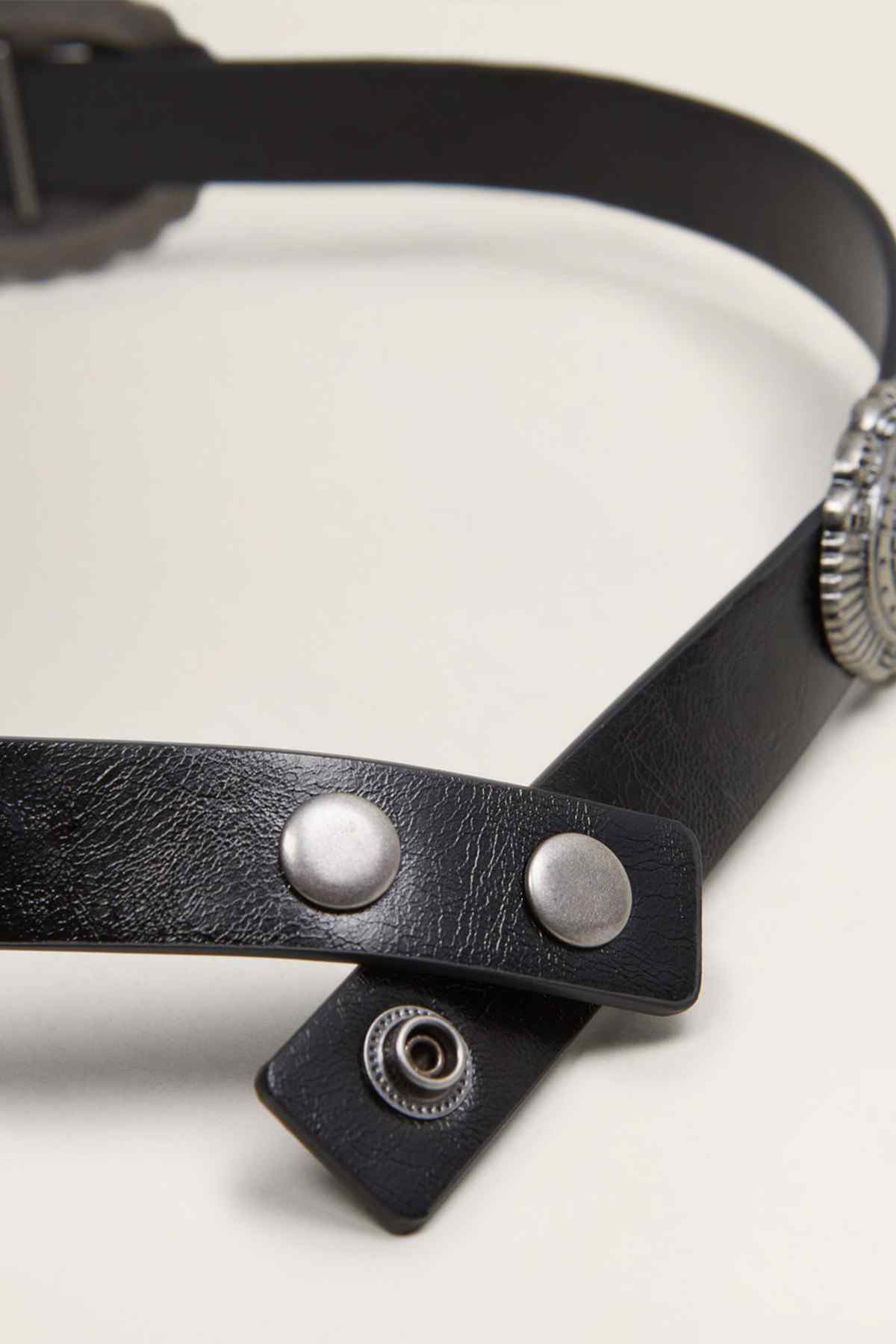 Black leather belt close-up with silver snap studs and overlapping strap end