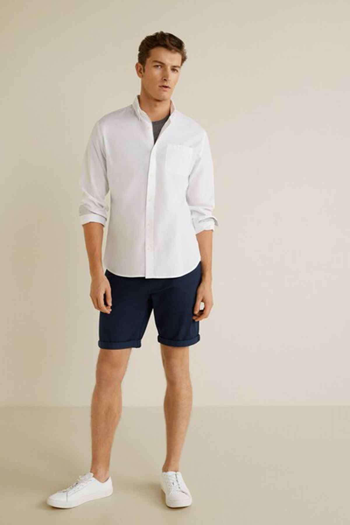 Navy shorts worn with a white button-up shirt, knee length
