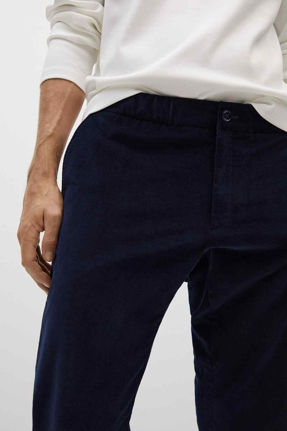 Mango navy trousers close-up: fly button and seam details