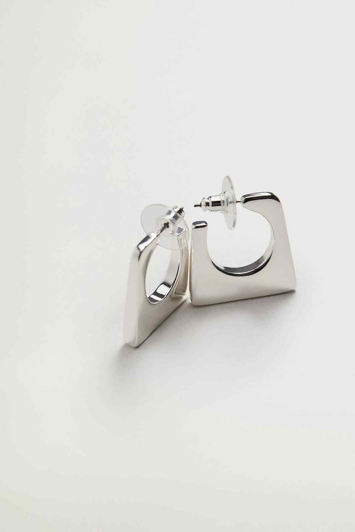 Silver hoop earrings with square backplate and hinged latch, side angle