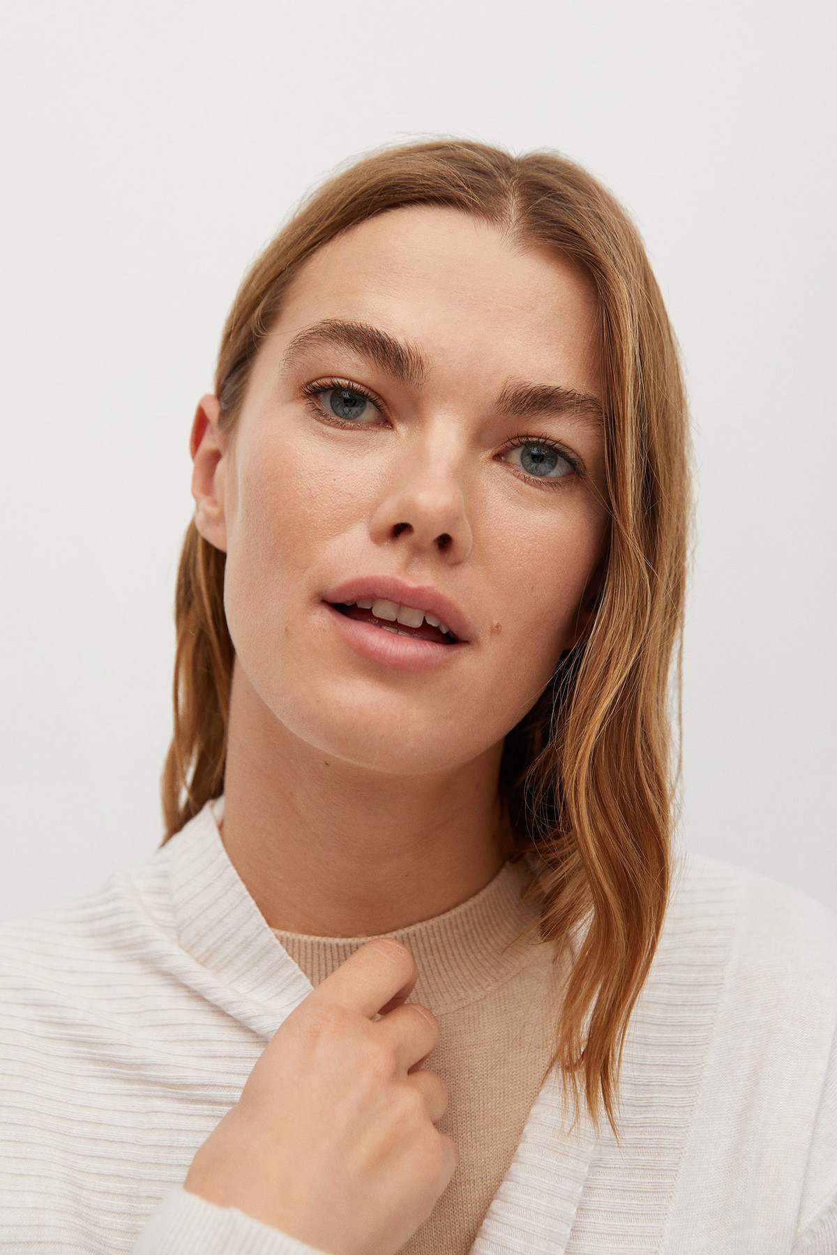 Ecru knit cardigan close-up with ribbed texture and front tie detail