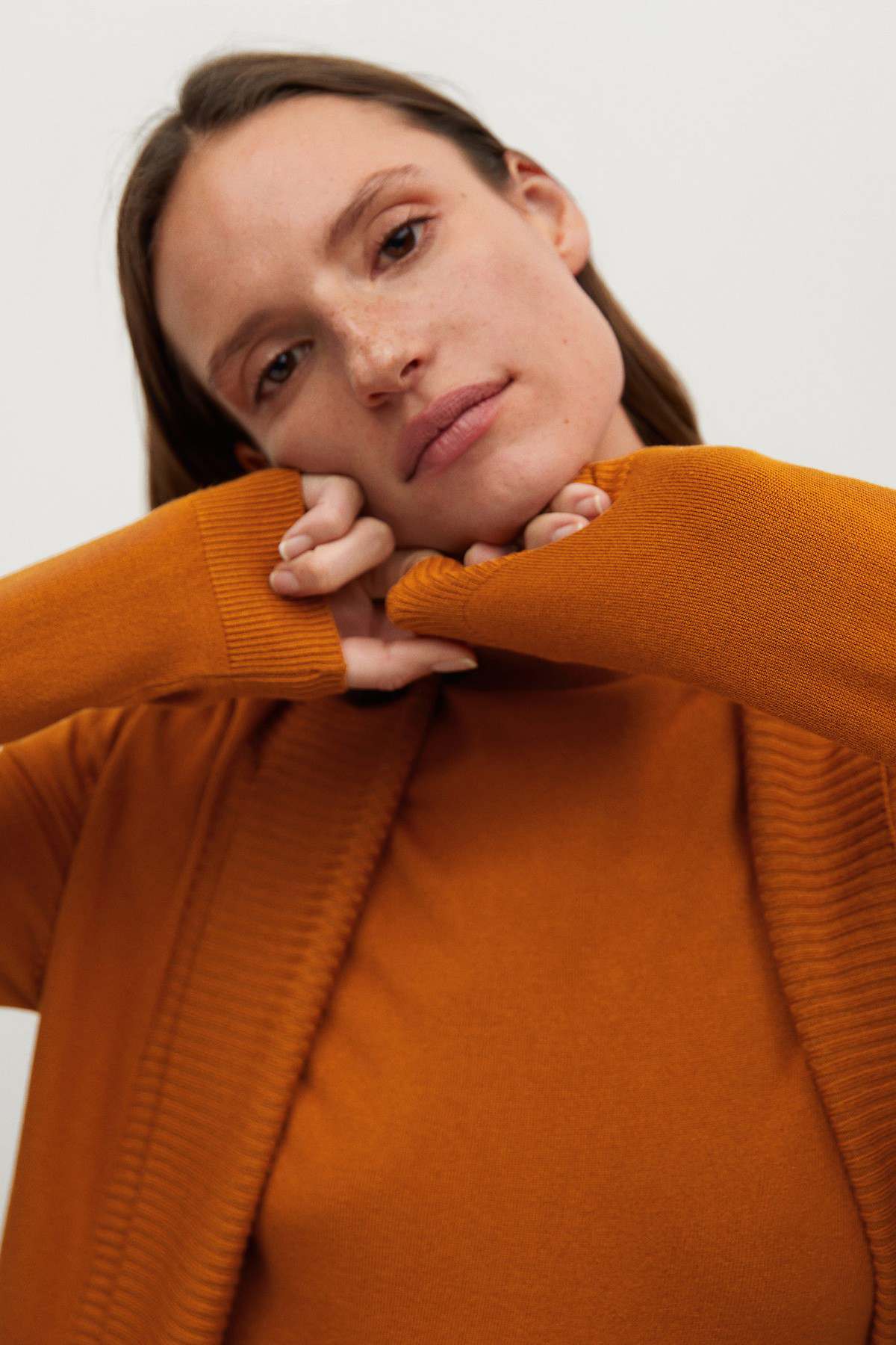 MANGO orange knit top close-up with ribbed V-neck wrap collar