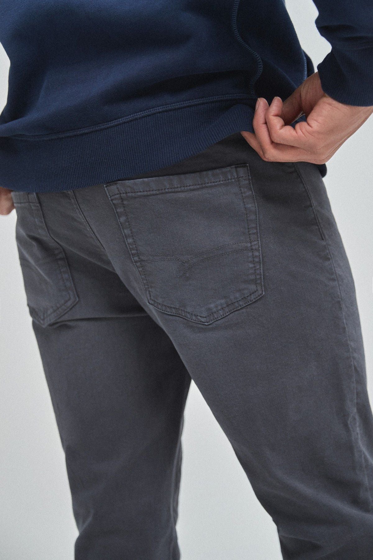 Navy jeans close-up with stitched front pockets and side seam