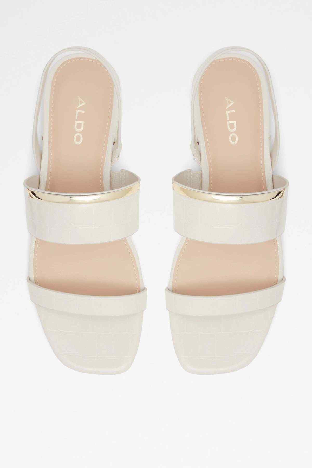 Cream and tan slide sandals with cushioned straps and visible logo on footbed