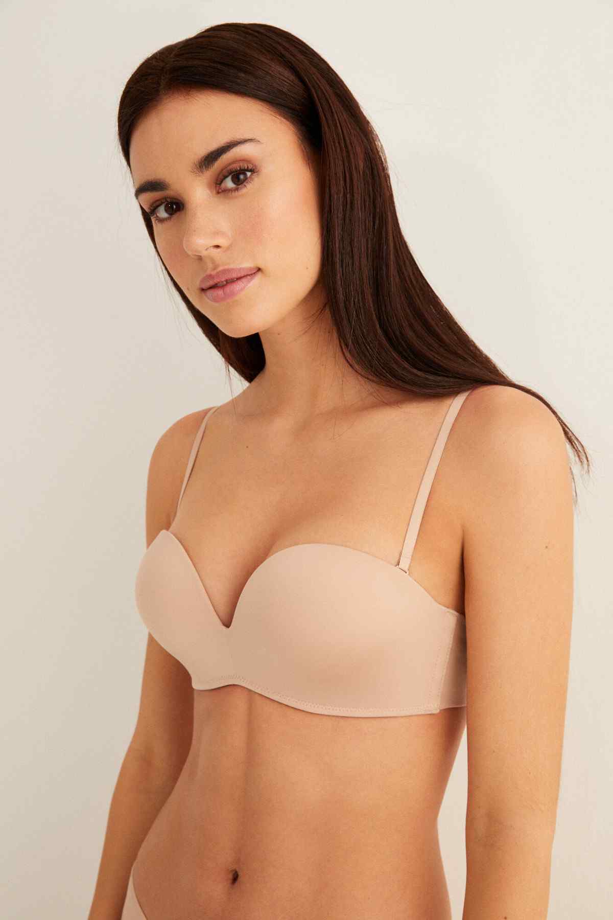 Skin-tone plunge bra with thin adjustable straps, cupped bust design