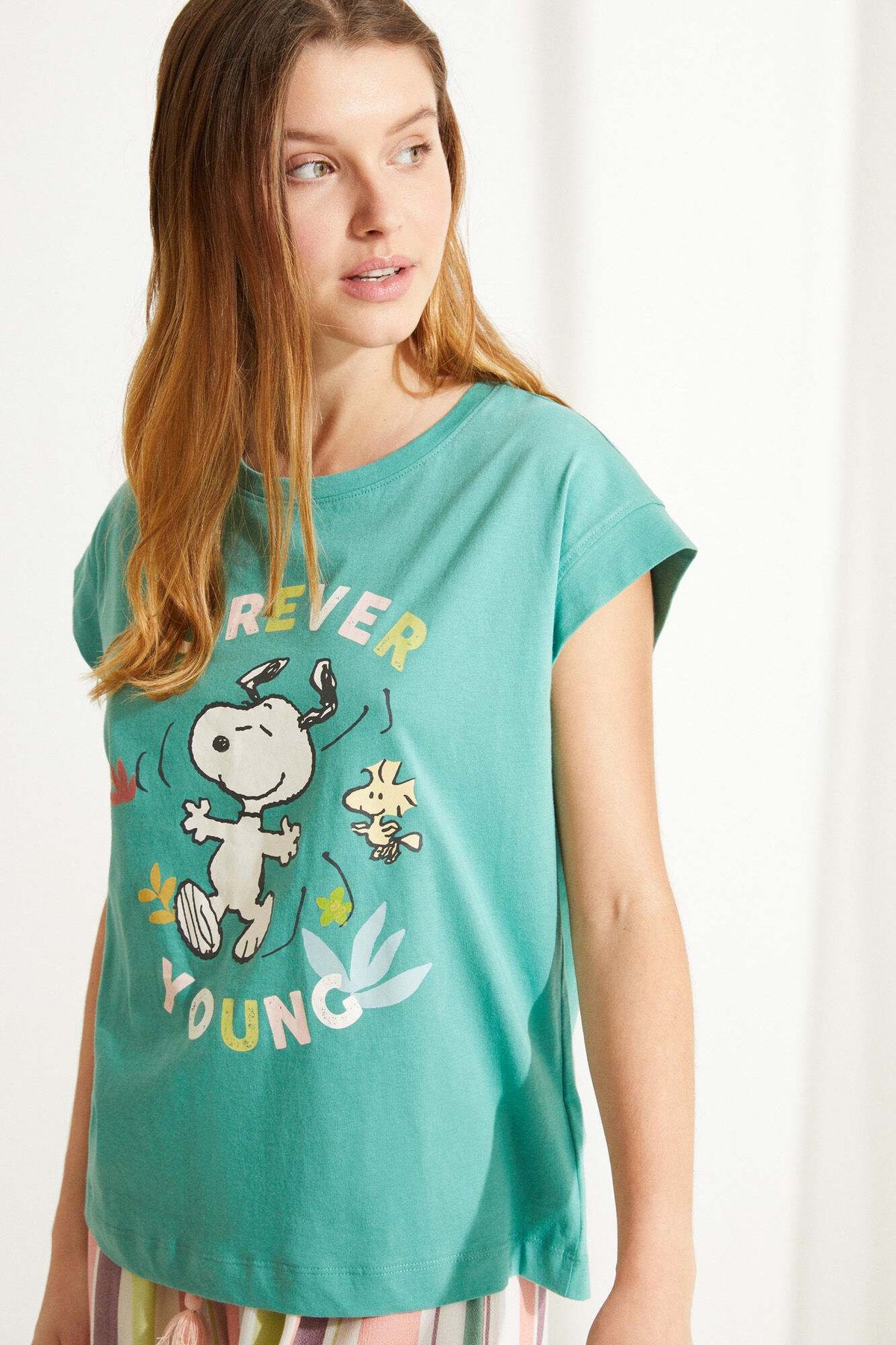 Women'secret teal green T-shirt with character graphic and 'YOUNG' text