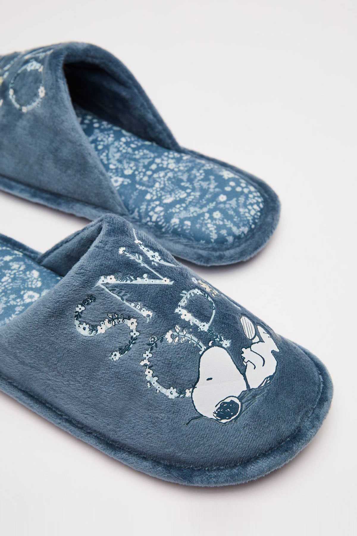Medium blue plush slipper with penguin graphic and textured blue patterned lining