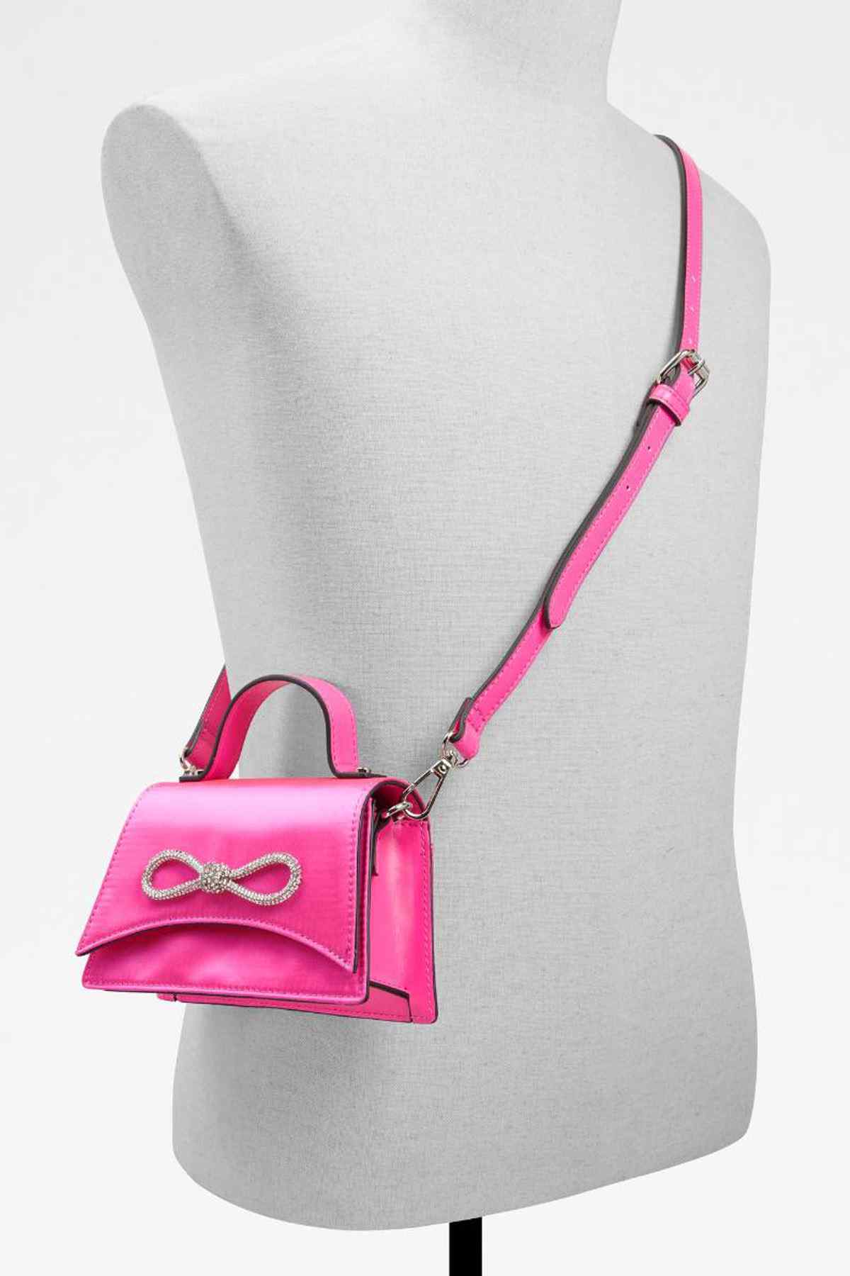 Bright pink mini handbag with adjustable shoulder strap and bow front