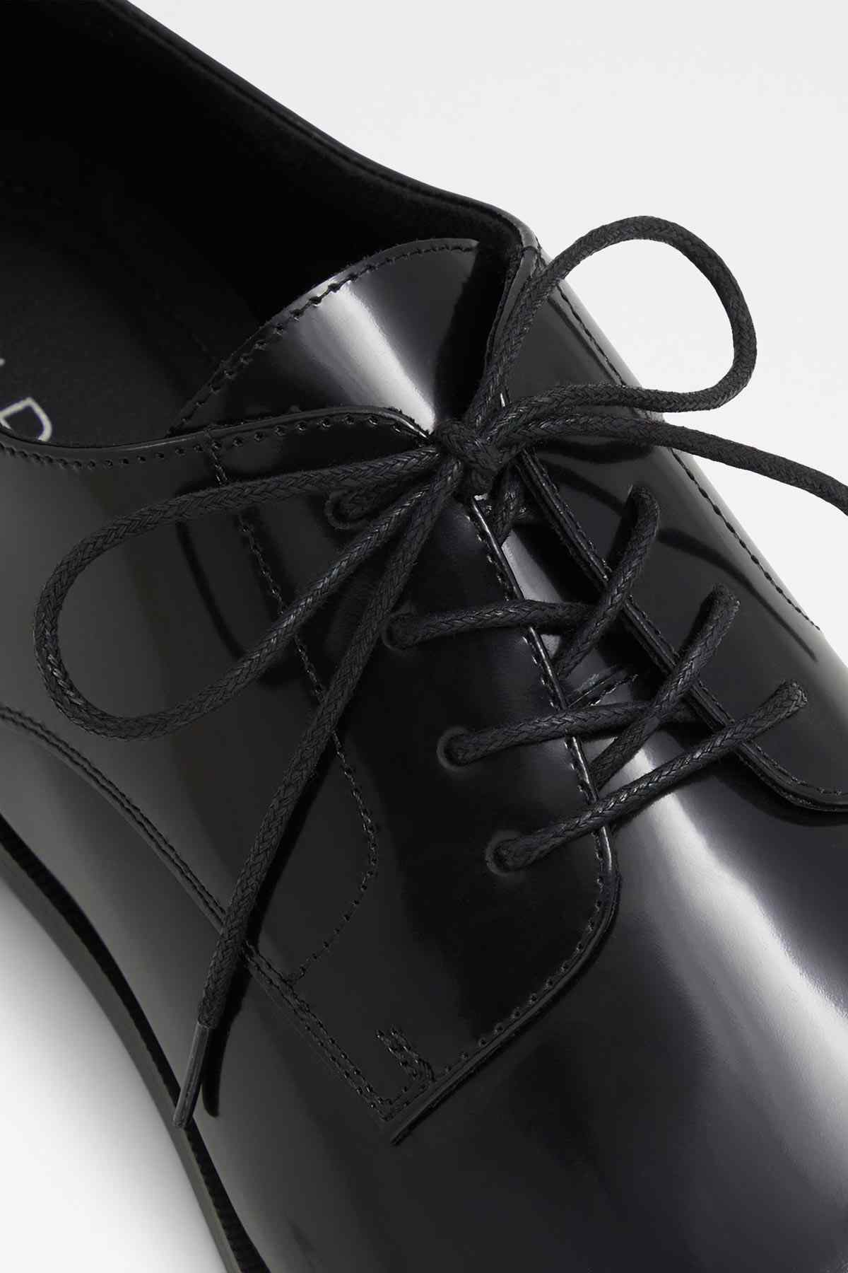 Black lace-up shoes with glossy finish and multiple lace eyelets