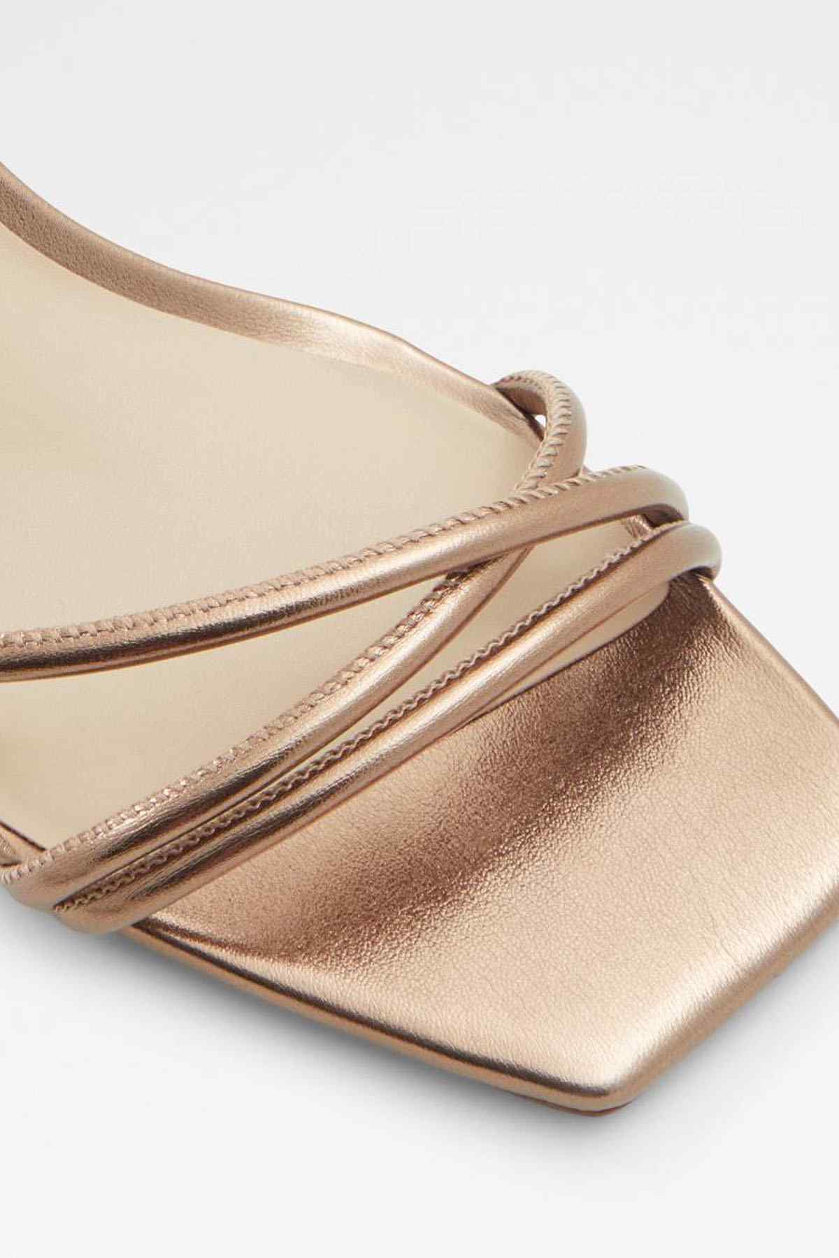 Bronze sandal upper close-up with braided-style straps and metallic finish