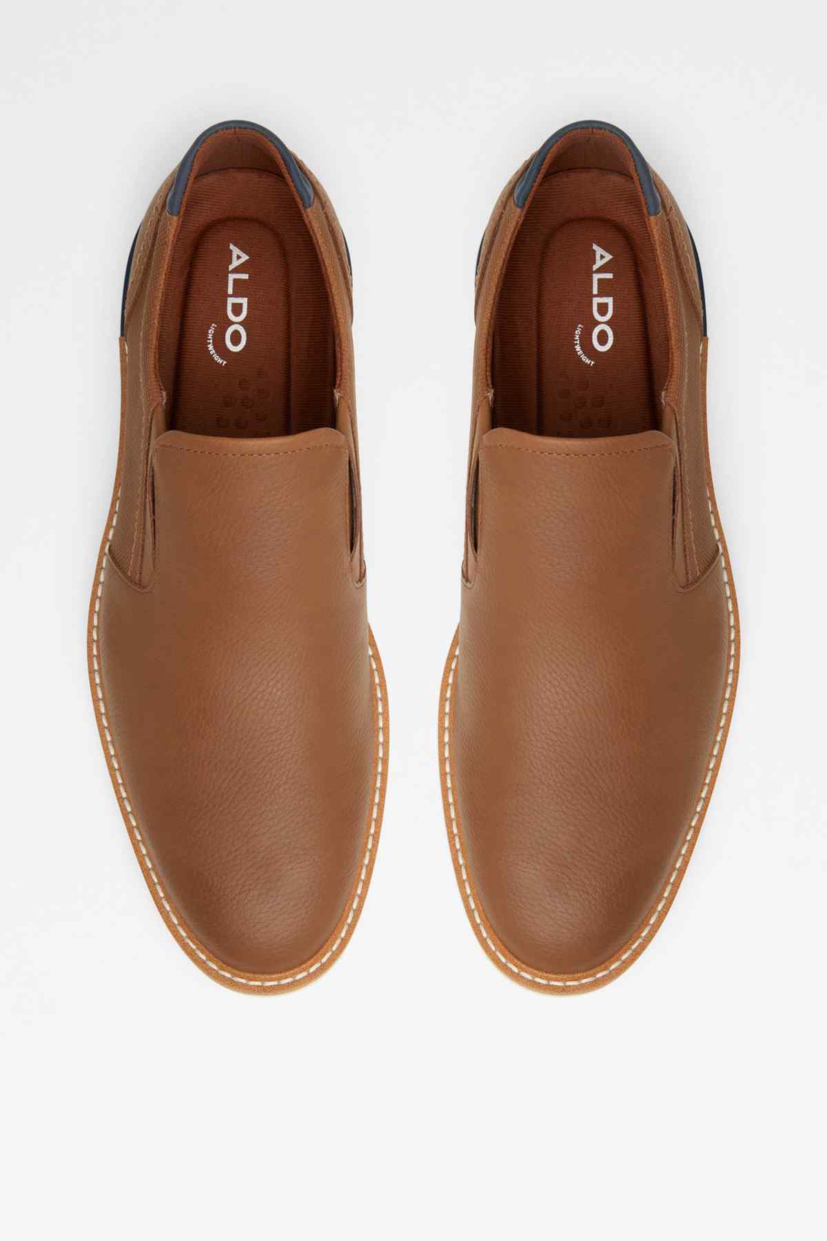 Pair of Cognac slip-on shoes with ALDO logo insides and white rubber sole