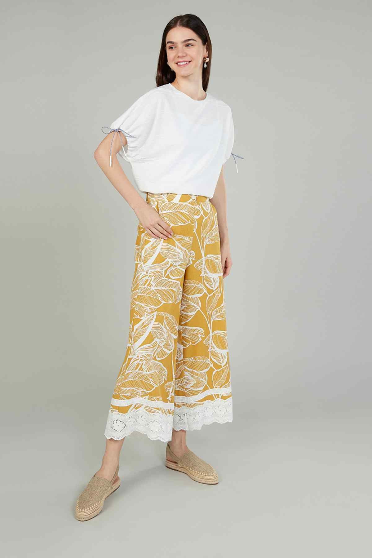 Ivory puff-sleeve blouse with tied sleeves and yellow leafy print skirt