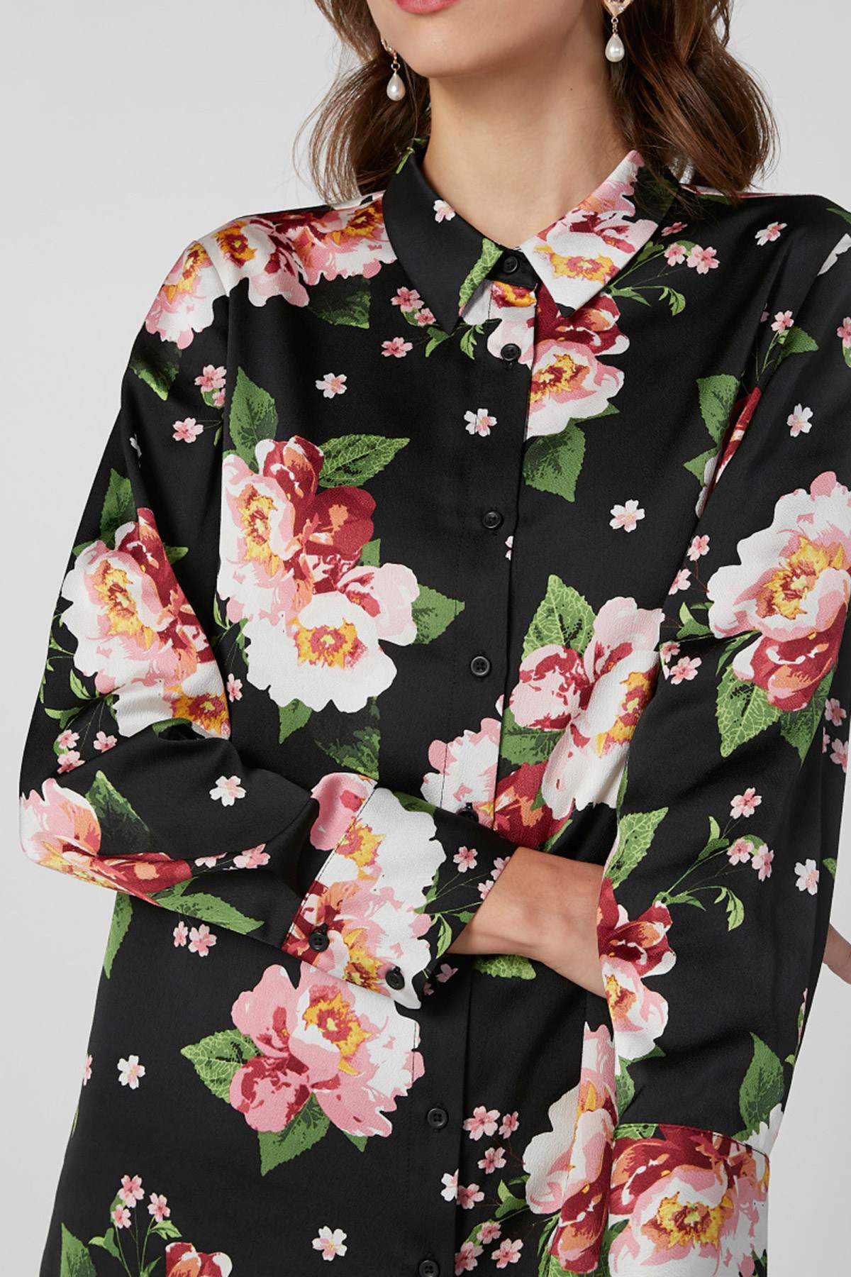 Black floral button-up blouse close-up with pink roses, green leaves, long sleeves