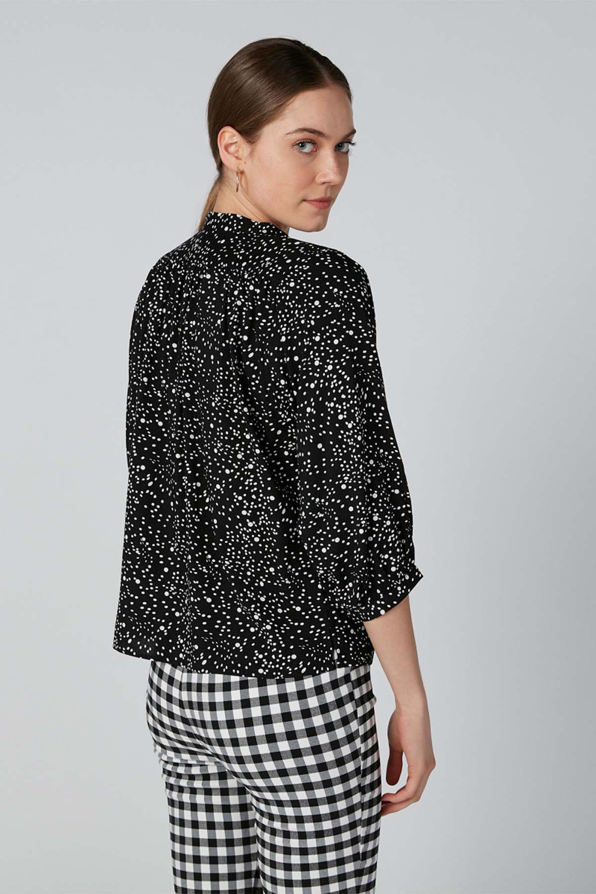 Black speckle blouse with stand collar and 3/4 sleeves, side/back view