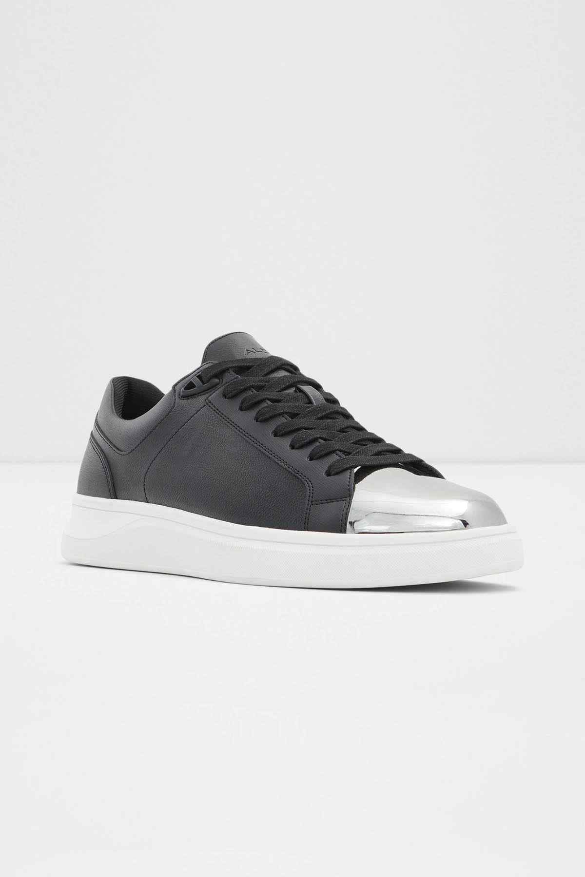 Black low-top sneakers with metallic silver side stripe and white rubber sole
