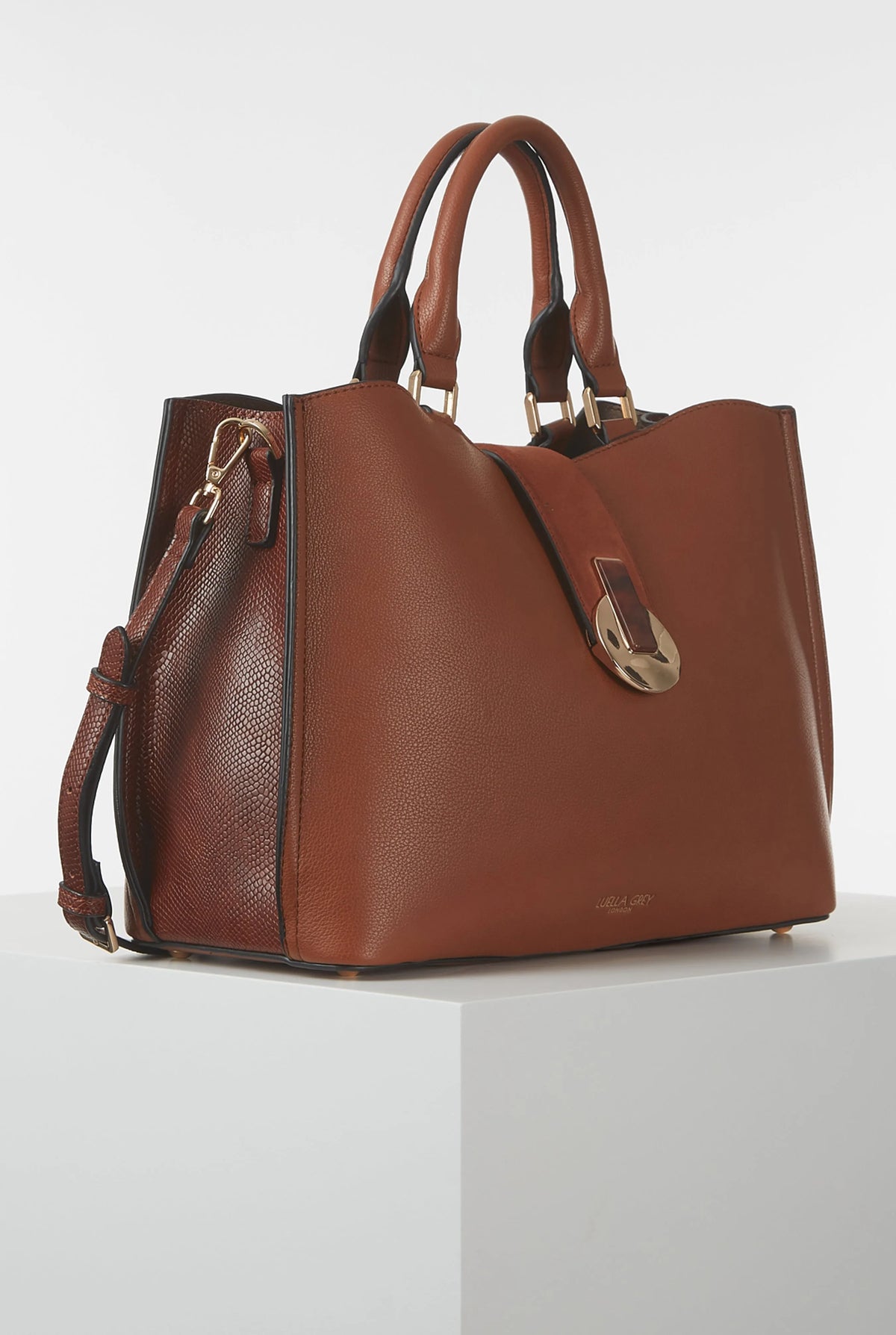 Brown leather tote bag with side zipper, crossbody strap, and top handles