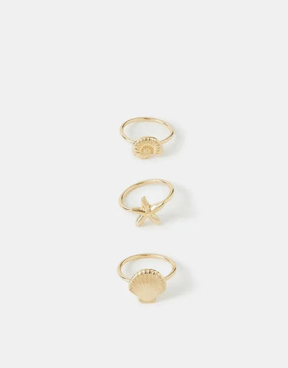 Gold-toned set of three rings: star, sunburst, and shell detail