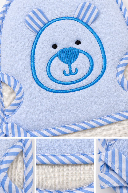 Close-up of embroidered bear face on blue hooded bath towel with striped edging