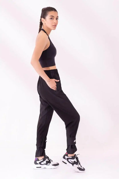Black halter sports bra and black jogger pants, side view