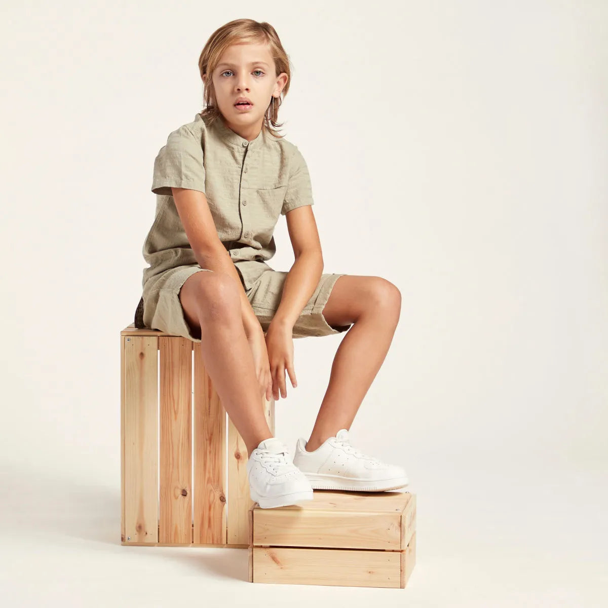 Children's light green short-sleeve shirt and shorts set, seated side view