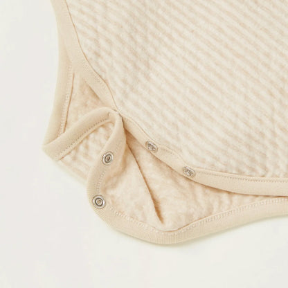 Beige striped bodysuit close-up: buttoned leg openings with snap crotch