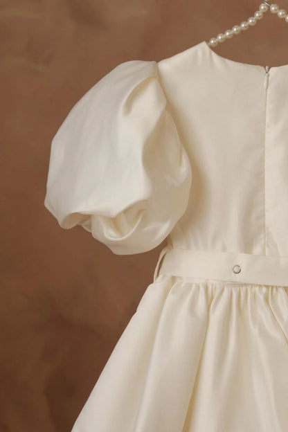 White dress close-up: puff sleeves and bodice with back button closure