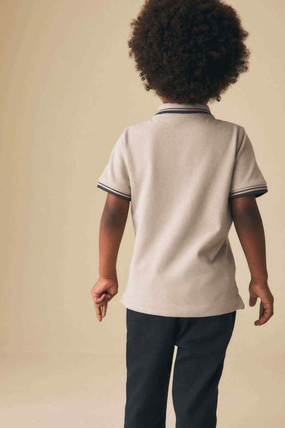 Kids stone polo shirt back view with navy striped trim on collar and sleeves