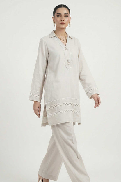Light grey tunic with embroidered collar and lace-trim cuffs, worn with trousers.
