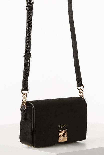Black flap shoulder bag with gold-tone clasp, front logo, and braided shoulder strap