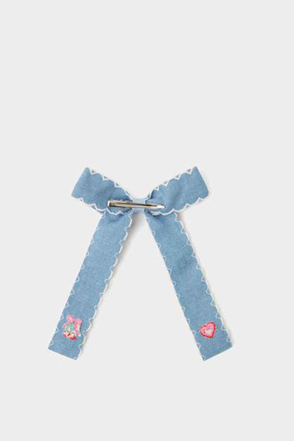 Blue fabric bow with scalloped edges, embroidered hearts, and center clip
