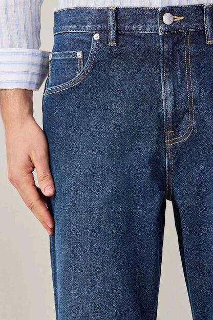 Dark blue denim jeans front with slash pockets and metal button