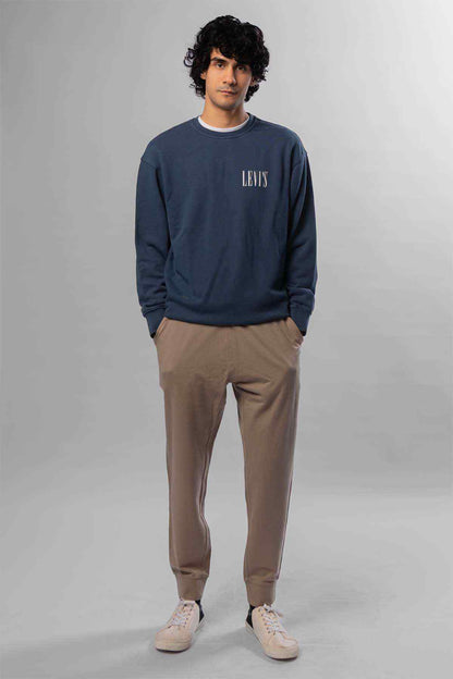 Levi's navy crewneck sweatshirt with chest logo; beige tapered pants and sneakers