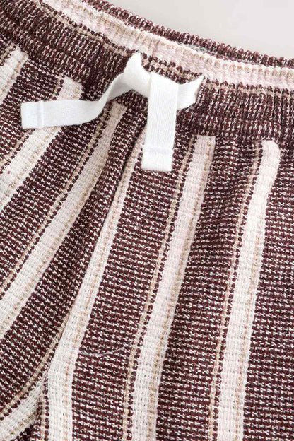 Brown and white striped shorts with white drawstring and textured elastic waistband