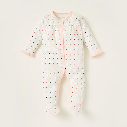 White baby footless romper with multicolor dot print and pink button placket