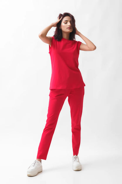 Red sleeveless top and tapered pants set, hands up pose