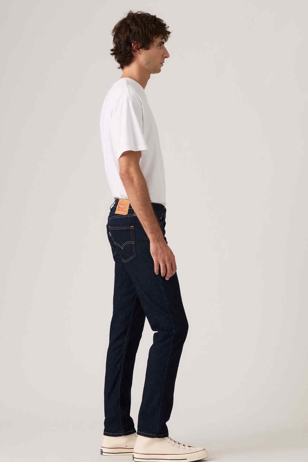 Dark blue denim jeans with contrast stitching and five-pocket design, side view