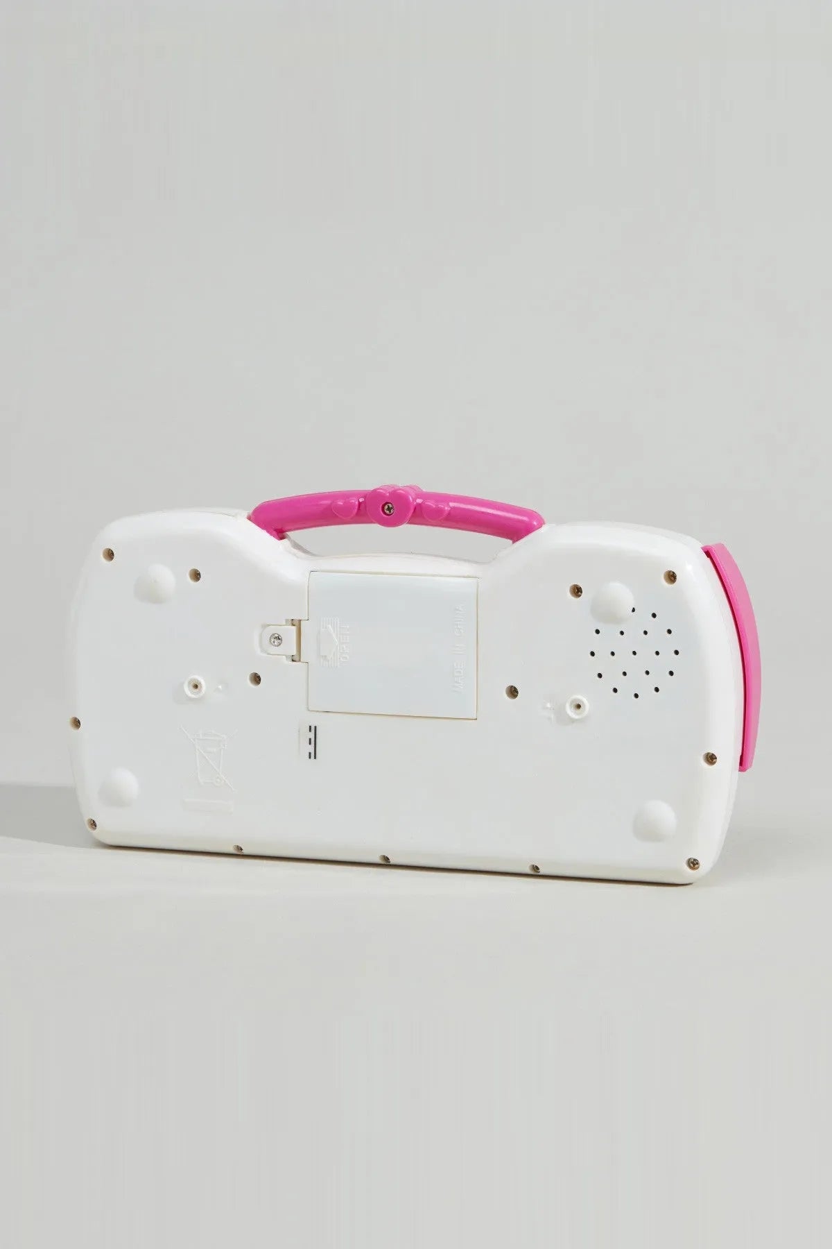 White and pink electronic keyboard toy back panel with speaker holes