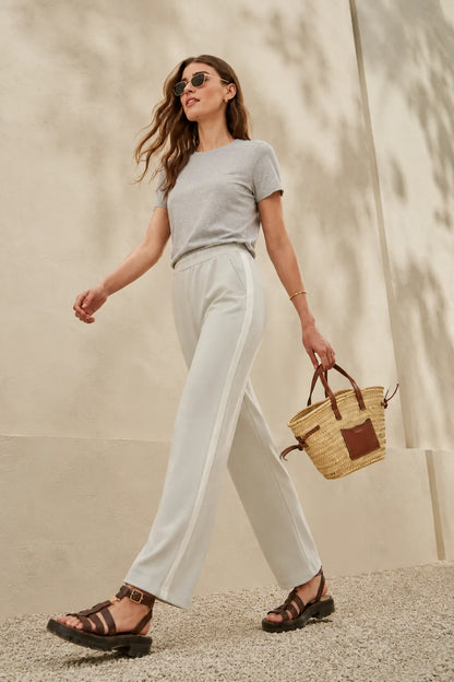 Grey t-shirt and white drawstring pants, side view with straw tote