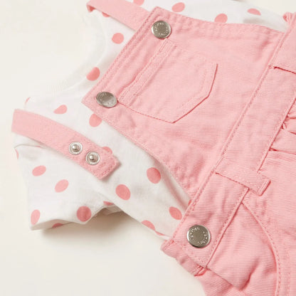 Pink overall dress close-up: snap buttons, pocket bib, stitched seams