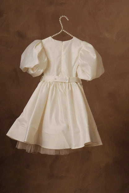 White puff-sleeve dress with gathered skirt and front button detailing, on hanger