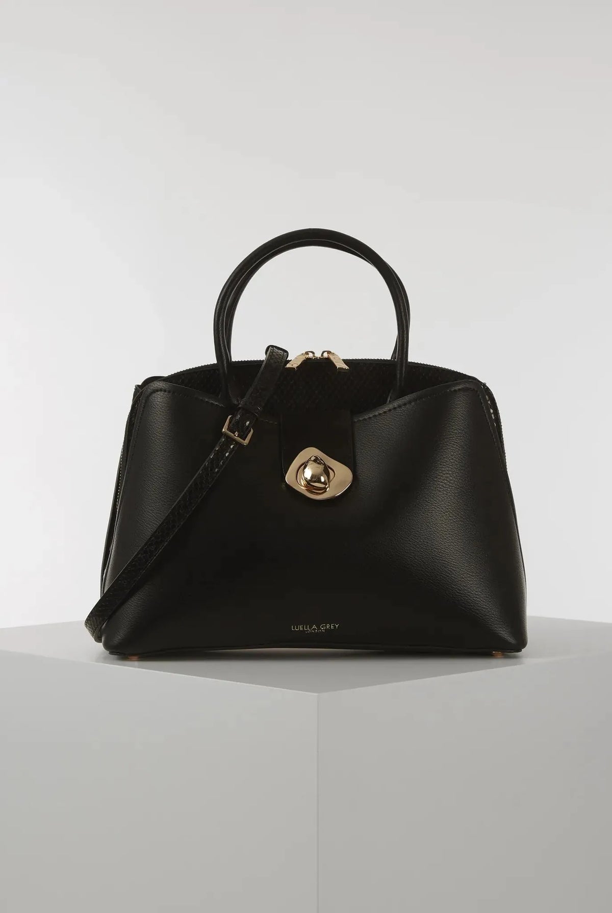 Black structured handbag with top handles and gold-tone front turn-lock clasp
