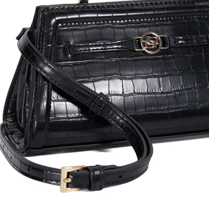 Close-up of black croc-embossed handbag front with gold emblem clasp and strap