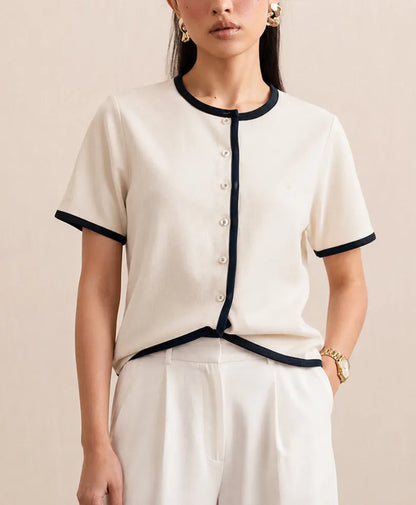 Fitted cream knit top with navy-trimmed crew neck, short sleeves, button placket