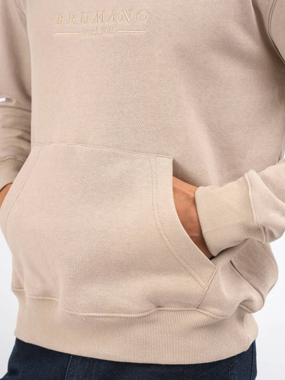 Beige hoodie front with small chest logo and kangaroo pocket; ribbed cuff