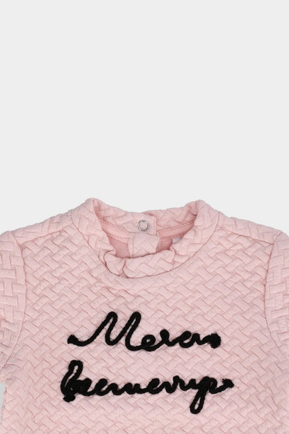 Pink textured baby top with black script front and buttoned round collar